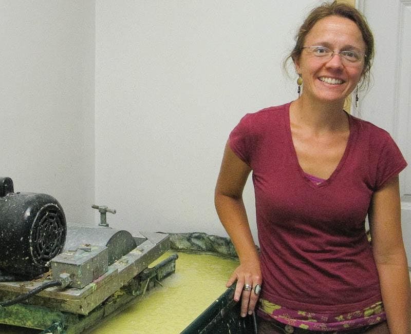 Sheryl Woodhouse-Keese, president of Twisted Limb Paperworks, stands next to Hollander beater Tuesday afternoon. The company uses the machine to produce pulp used in the manufacture of 100% recycled paper products.