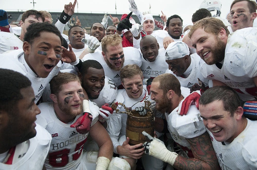 Senior quarterback Nate Sudfeld holds the Oaken Bucket and members of the football team celebrate after beating Purdue, 54-36 Saturday at Ross-Ade Stadium. 