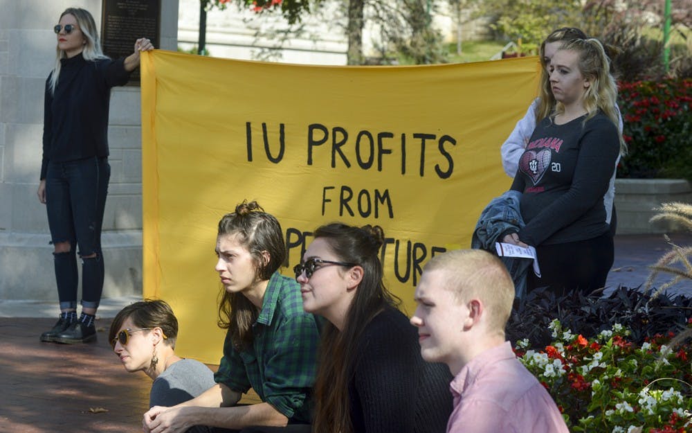 Students Against State Violence chalk the sidewalks and sit in protest during the SASV rally Saturday afternoon at the Sample Gates. SASV tackled a variety of issues during homecoming weekend including Black Lives Matter, rape culture on campus and the systematic oppression of Native Americans.