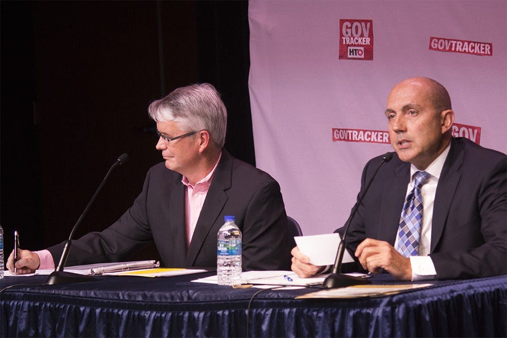 John Hamilton (D) writes some notes while John Turnbull (R) goes through his opening statement during the mayoral debate on Thursday night at Monroe County Public Library.
