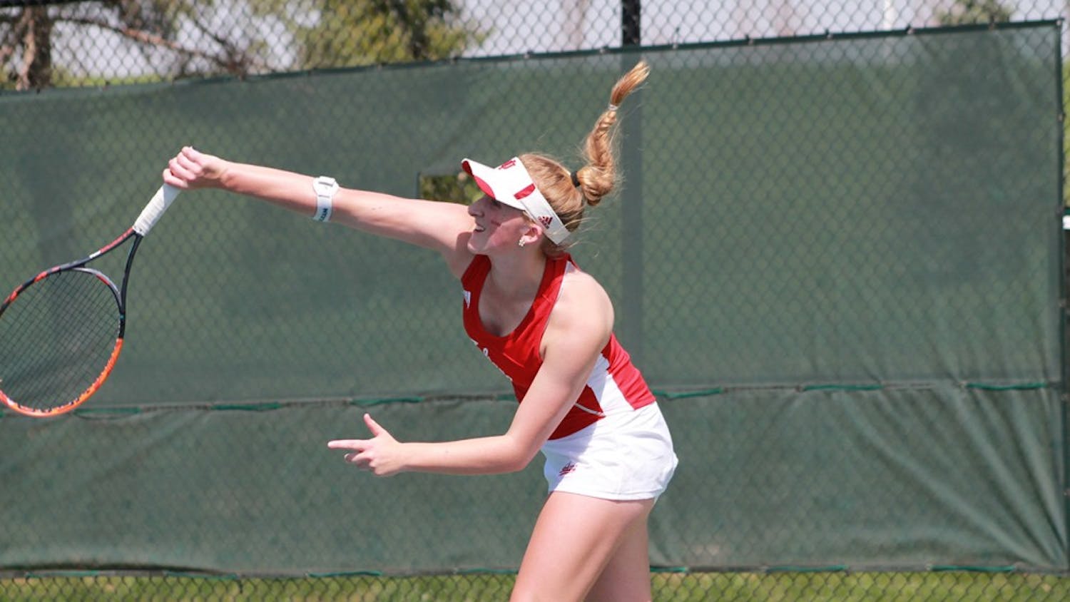 Senior Kim Schmider serves the ball in a singles match Sunday morning. IU took on Northwestern in their final home match of the season.
