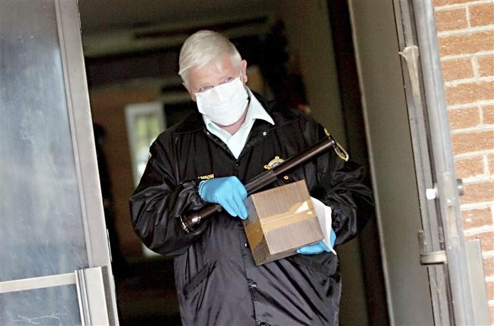 Tom Branson, Lake County coroner's chief investigator, carries a box containing cremated remains out of the former Serenity Gardens Funeral Home in Gary, Ind., Thursday May 28, 2009.  Four decomposed bodies were discovered earlier this week in the building that has been closed for several years after former funeral director Darryl Cammack lost his funeral license. 