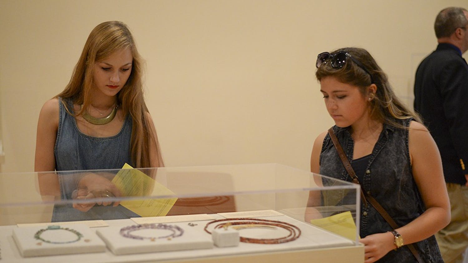 Freshman Emmaline Terry, left, and sophomore Alex Miller, right, look at a display on the second floor of the IU Art Museum during the MIX at the Museum event on Friday.