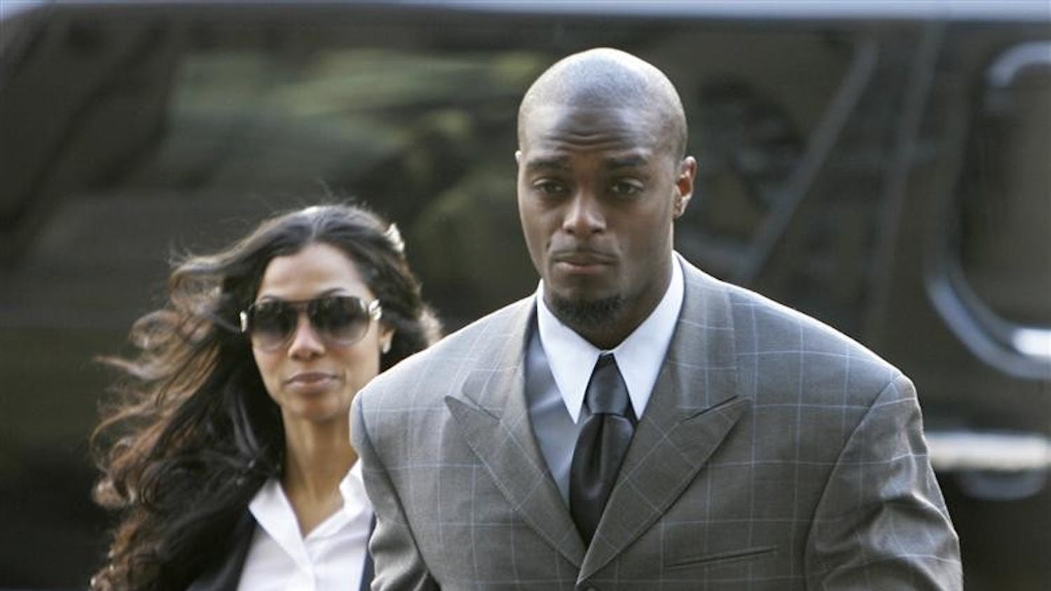 New York Giants football player Plaxico Burress enters the criminal courts building wife his wife, Tiffany, Tuesday in New York. A gun possession case against Burress has been adjourned until June 15. Burress accidentally shot himself in the leg with an unlicensed gun at a nightclub last year.
