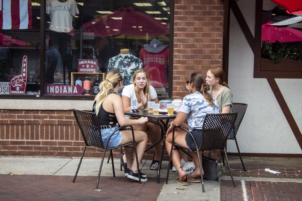 8月29日，一群朋友坐在尼克英语小屋前。尼克餐厅是利用柯克伍德大道关闭的机会在周末将更多座位移到户外的几家餐厅之一。