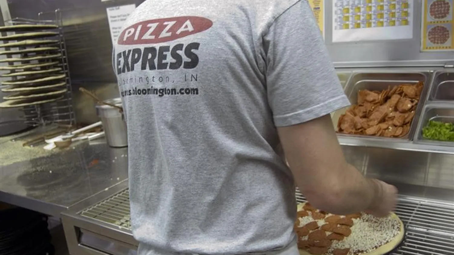 Cody Milestone prepares a pizza Wednesday evening at the Pizza Express on 10th Street. By the end of the semester, the popular pizza chain will be known as Pizza X, which can be federally trademarked so that the company can prevent future legal issues.
