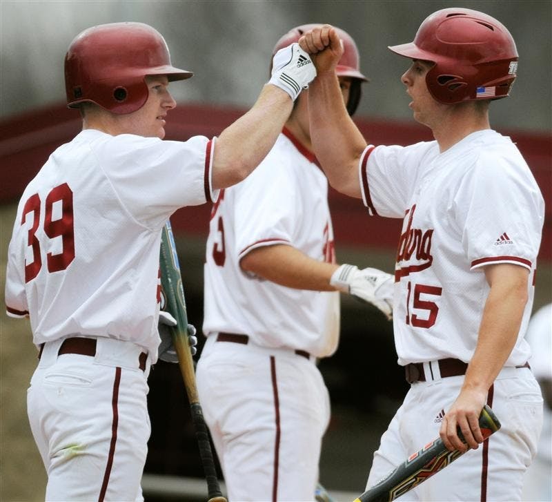 IU sophomore outfielder T.C. Kipp, left, congratulates senior outfielder Chris Hervey after Hervey scored a run during a game against Minnesota March 27 at Sembower Field. IU lost 12-5.