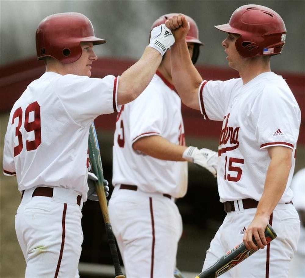 IU sophomore outfielder T.C. Kipp, left, congratulates senior outfielder Chris Hervey after Hervey scored a run during a game against Minnesota March 27 at Sembower Field. IU lost 12-5.