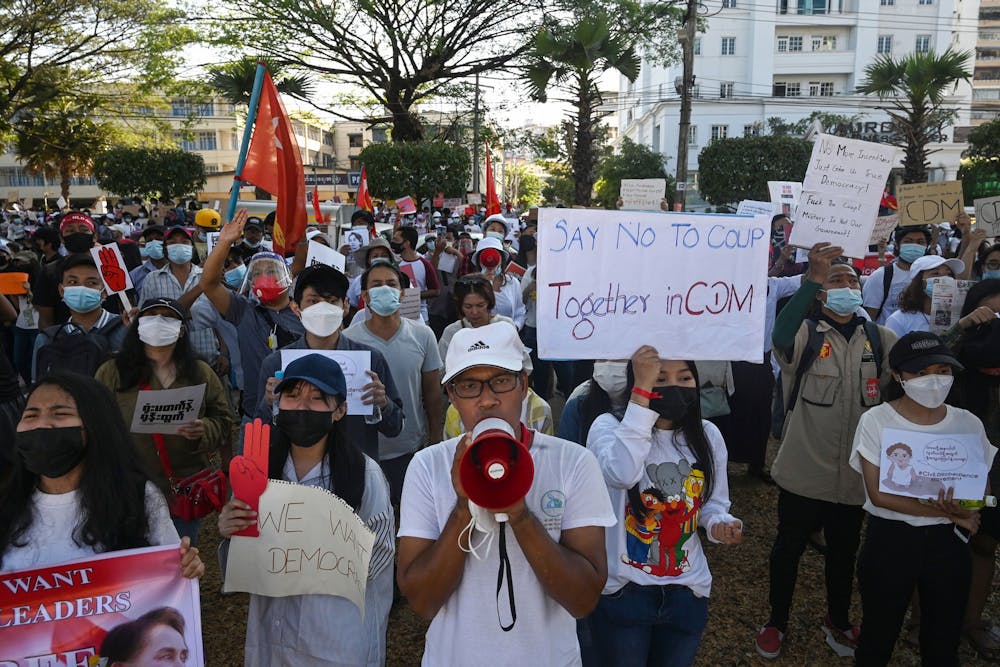 2021年2月11日，在仰光的缅甸中央银行前，抗议者们举着反对军事政变的标语。印第安纳州是美国缅甸难民人数最多的州之一。