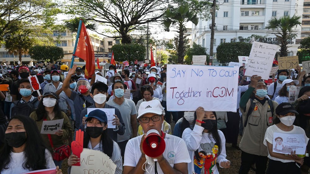 Protesters hold signs during a demonstration against the military coup on Feb. 11, 2021 in front of the Central Bank of Myanmar in Yangon. Indiana is home to one of the largest Burmese refugee populations in the United States.