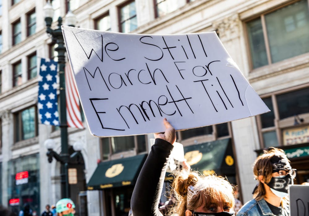 <p>A woman holds a sign in honor of Emmett Till during a protest June 13, 2020 in Chicago.</p>