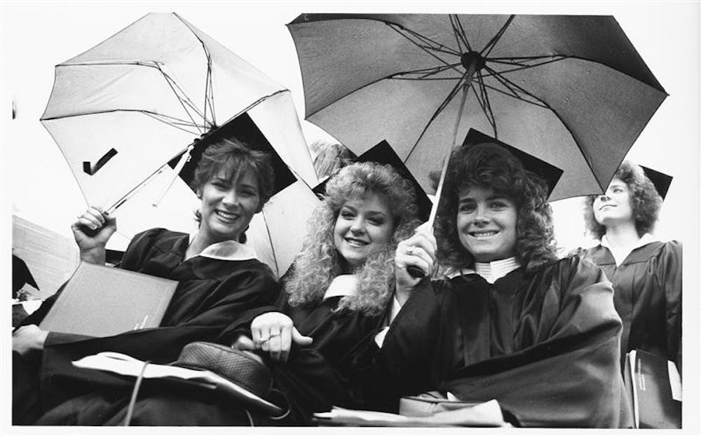 Three graduates from the class of 1990 smile, despite the weather. While these women planned the beginnings of the rest of their lives, current IU freshmen were just beginning theirs.