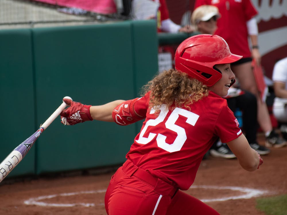 Indiana senior designated player Cora Bassett hits the ball April 15, 2023, against Nebraska at Andy Mohr Field in Bloomington. Bassett, Brianna Copeland and Heather Johnson were named to the 2023 College Sports Communicators Academic All-District Team. 