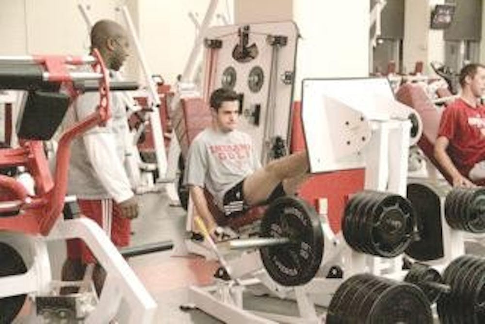 Freshman Max Kollin works with Je'Ney Jackson in the weight room. 