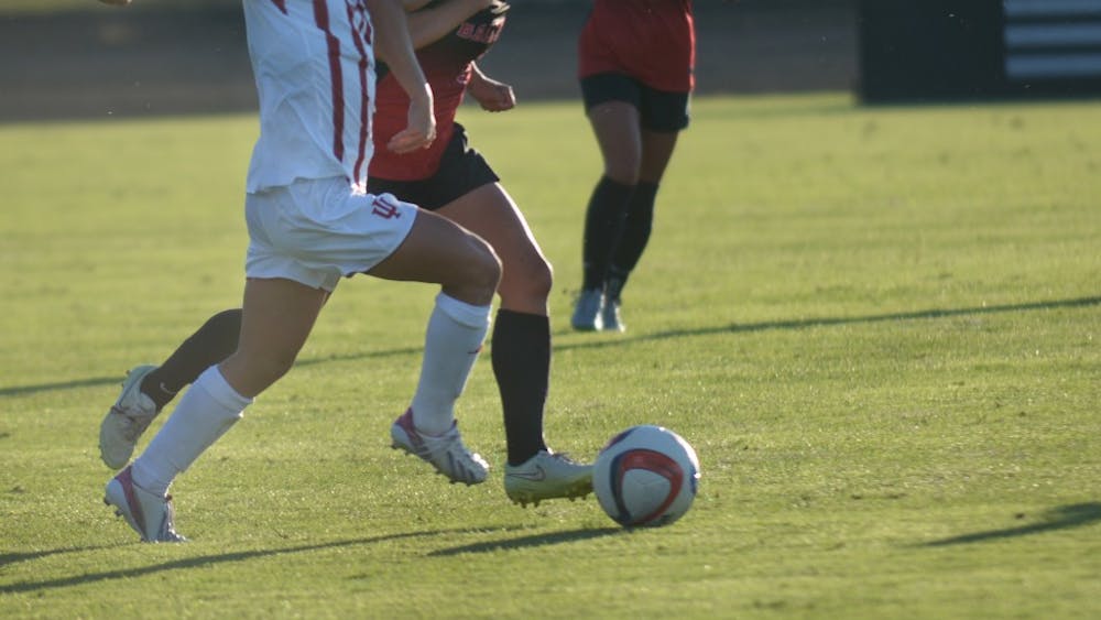 Sophomore Midfielder Kayla Smith holds off a Ball State University Cardinals' defender at Bill Armstrong stadium on Sunday evening. IU tied the game 1-1.