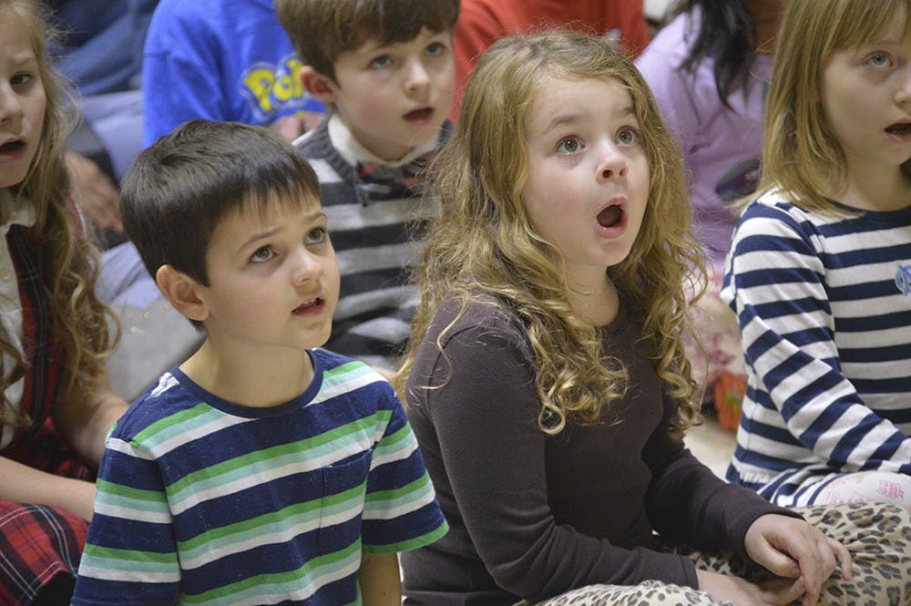 Etienne Lamb (left) and Story Bolton watch the IU Children's Choir director as they rehearse for the program's Winter Concert. The performance will feature a mixture of Christmas, Hanukkah and secular songs, and it begins at 1 p.m. Saturday at St. John the Apostle Church. 