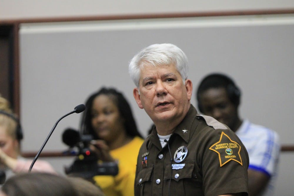 <p>Monroe County Sheriff Brad Swain speaks about how the purchase of the armored vehicle is to protect officers of Bloomington while a member of the audience shouts slurs at him. Swain and several family members of police officers spoke in favor of the armored vehicle Tuesday, Feb. 20.</p>
