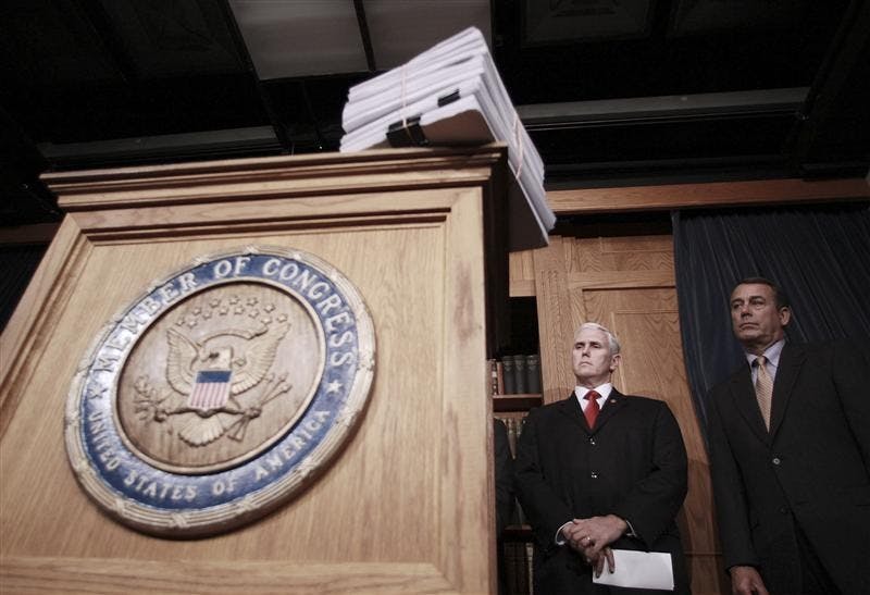 With a copy of the stimulus legislation on the podium, House Minority Leader John Boehner of Ohio, right, and Rep. Mike Pence, R-Ind., prepare to meet with reporters on Capitol Hill in Washington, Friday, after the House passed the stimulus legislation. President Barack Obama is expected to sign the bill today.