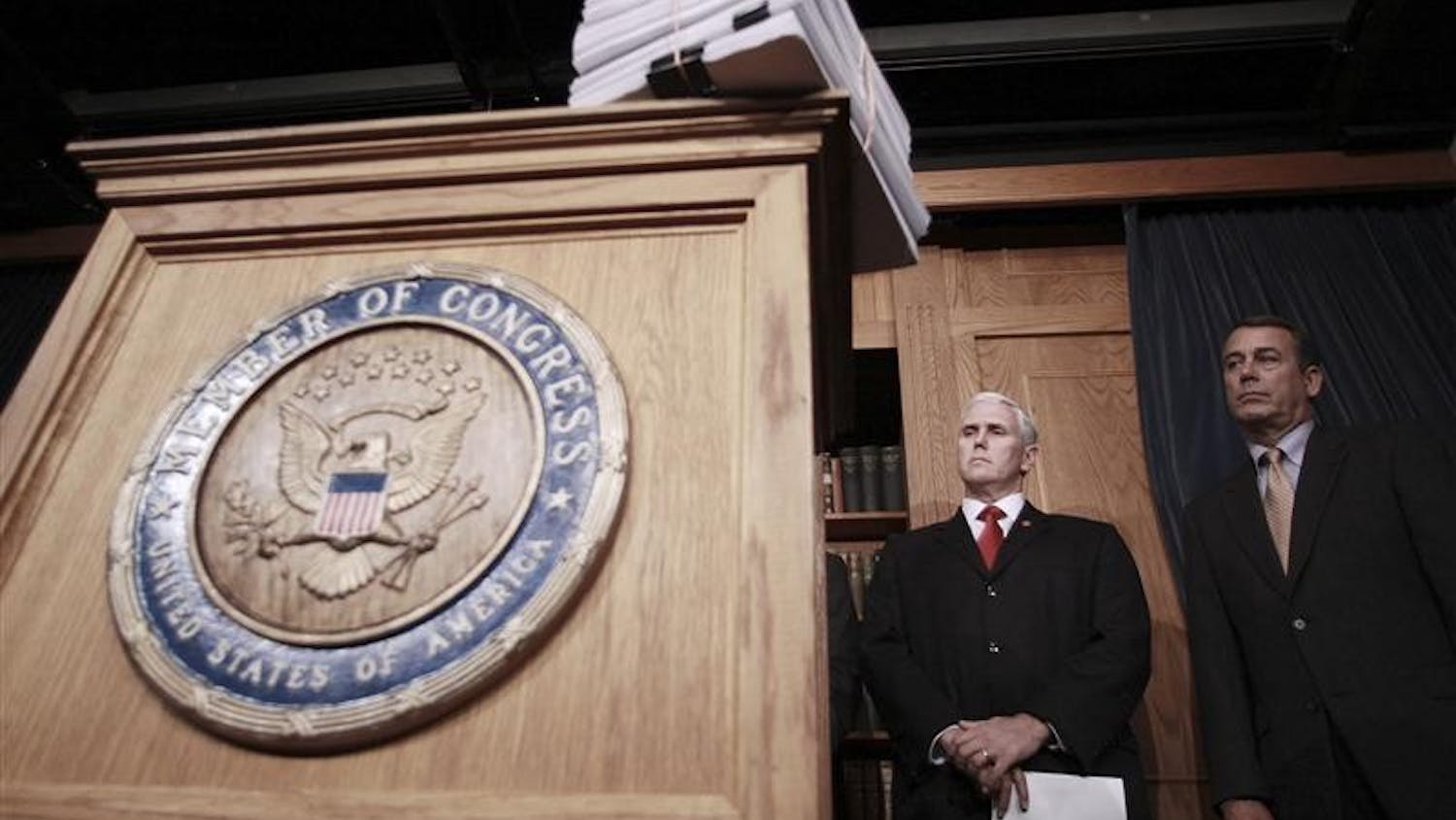 With a copy of the stimulus legislation on the podium, House Minority Leader John Boehner of Ohio, right, and Rep. Mike Pence, R-Ind., prepare to meet with reporters on Capitol Hill in Washington, Friday, after the House passed the stimulus legislation. President Barack Obama is expected to sign the bill today.