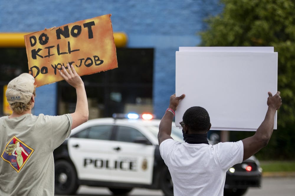 6月1日，在第三大街，抗议者手持标语走向警车