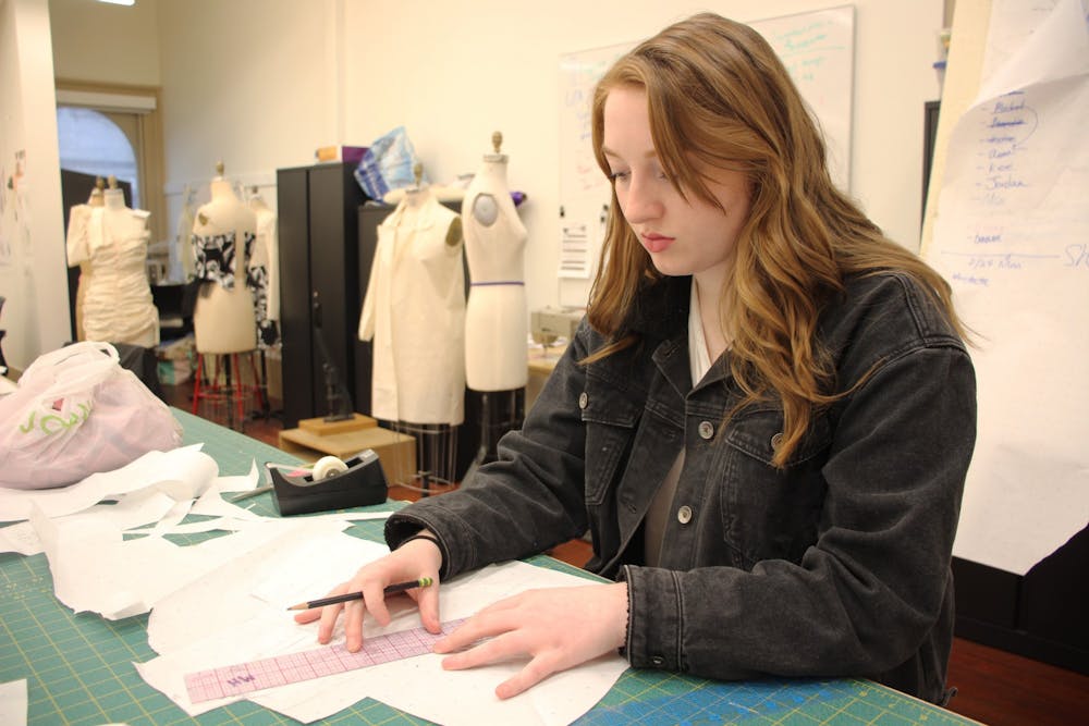 <p>Junior Meredith Higgins, a fashion design major, sketches her pieces Feb. 24 in Kirkwood Hall. Higgins designed a fashion line for her senior collection. </p>