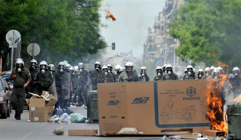 Riot police stand behind a burning roadblock in the northern Greek port city of Thessaloniki, Wednesday, May 5, 2010. Deadly riots over harsh new austerity measures engulfed the streets of Athens on Wednesday, and three people were killed as angry protesters tried to storm parliament, hurled Molotov cocktails at police and torched buildings. Tens of thousands of people took to the streets as part of nationwide strikes to protest new taxes and government spending cuts demanded by the International Monetary Fund and other European nations before heavily indebted Greece gets a $141 billion bailout package of loans to keep it from defaulting.