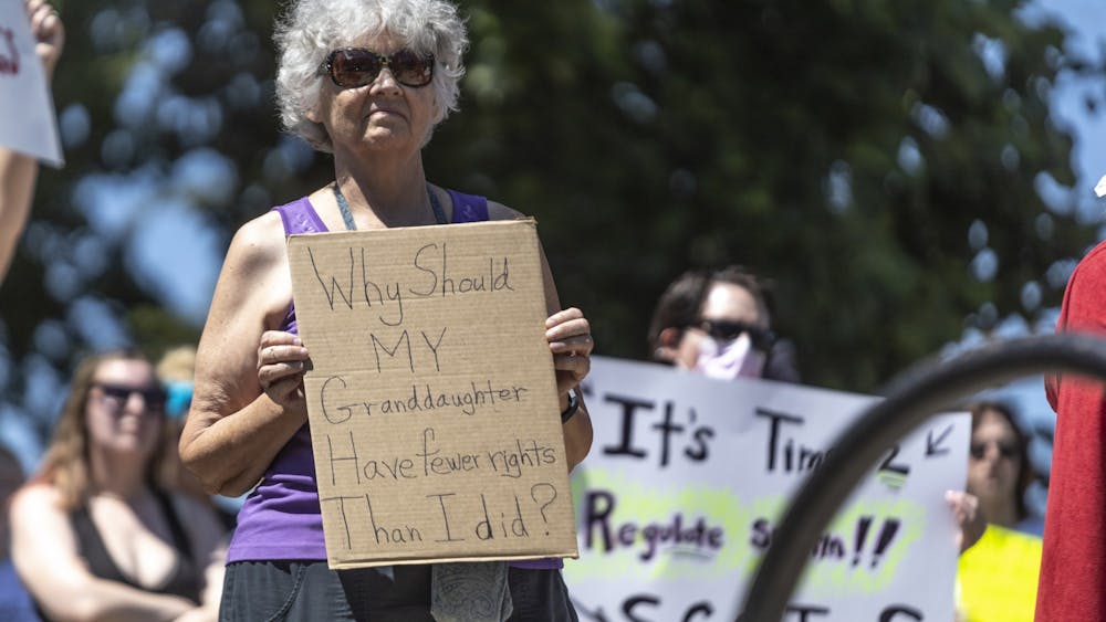 A woman holds up sign that reads, &quot;Why should my granddaughter have fewer rights than I did?&quot; June 27, 2022, in front of the Monroe County Courthouse during a protest for reproductive rights following the Supreme Court&#x27;s decision to overturn Roe v. Wade.