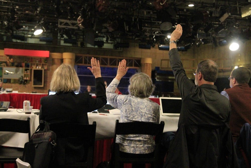 <p>Faculty members raise their hands in agreement with a proposed new lecturer rank during the Bloomington Faculty Council meeting in March 2018.&nbsp;</p>