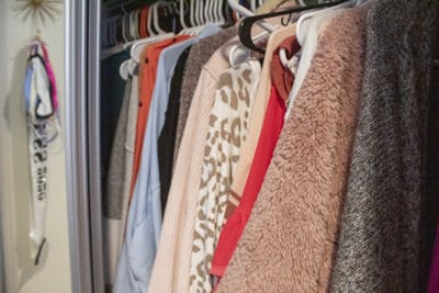 Clothing items hang in a closet Oct. 11 in an off-campus apartment. When moving into college, it is important to think about how much closet space you will have while deciding how many clothes to pack.