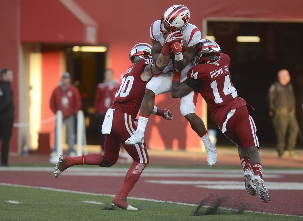 Safety Chase Dutra (30) and cornerback Andre Brown, Jr. (14) attempt to tackle Rutger's wide receiver Leonte Carroo on Saturday at Memorial Stadium. Carroo scored on the play.