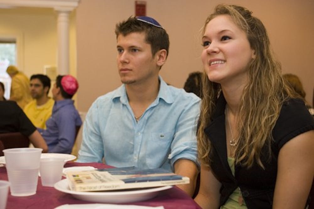 Sophomores Vladislav Ginzburg and Jennifer Hanono talk with friends Monday evening during the Passover Seder at Hillel Center.  Passover began at sundown Monday.