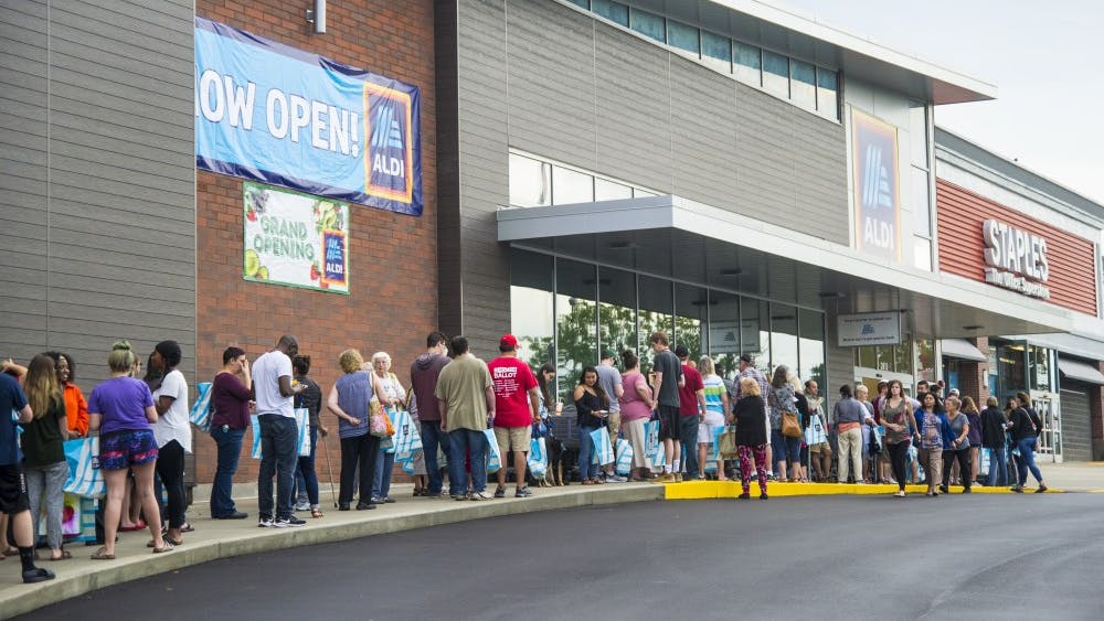 People stand in line Aug. 22 at the grand opening of Aldi on East Third Street. The line to get into the store wrapped around the side of the store and down Williamsburg Drive.