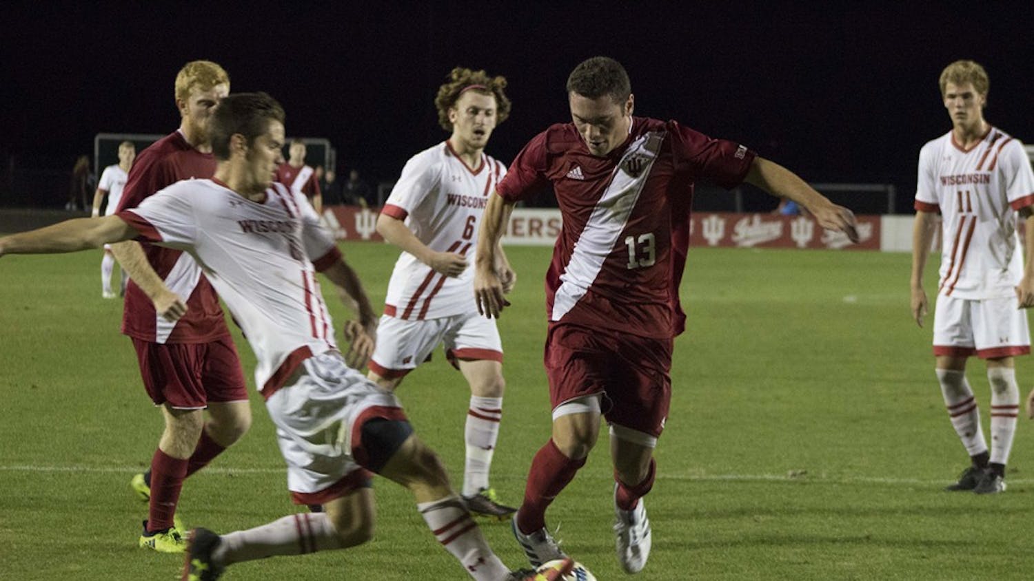 Junior midfielder Francesco Moore attempts to protect the ball from a Wisconsin defender. The IU men's soccer team defeated Wisconsin 2-1 in overtime Saturday night.&nbsp;