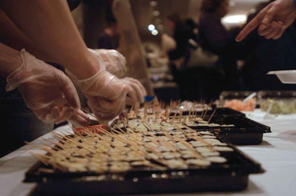 IDS File PhotoJoe Pacold and Janice Lin dish out sushi to patrons at the Taste of Asia 2006. Many Bloomington restaurants provided free Asian food at the event, held Sunday in the IU Auditorium.