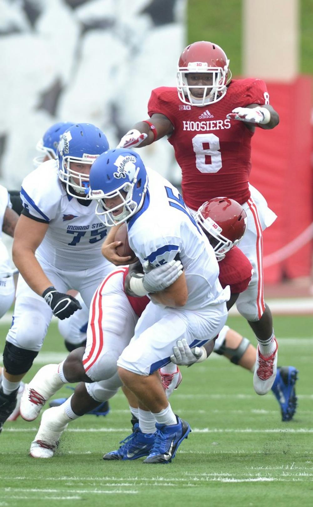 Freshman Tegray Scales jumps over senior Bobby Richardson as they make a tackle in IU's game against Indiana State on Aug. 30 at Memorial Stadium.