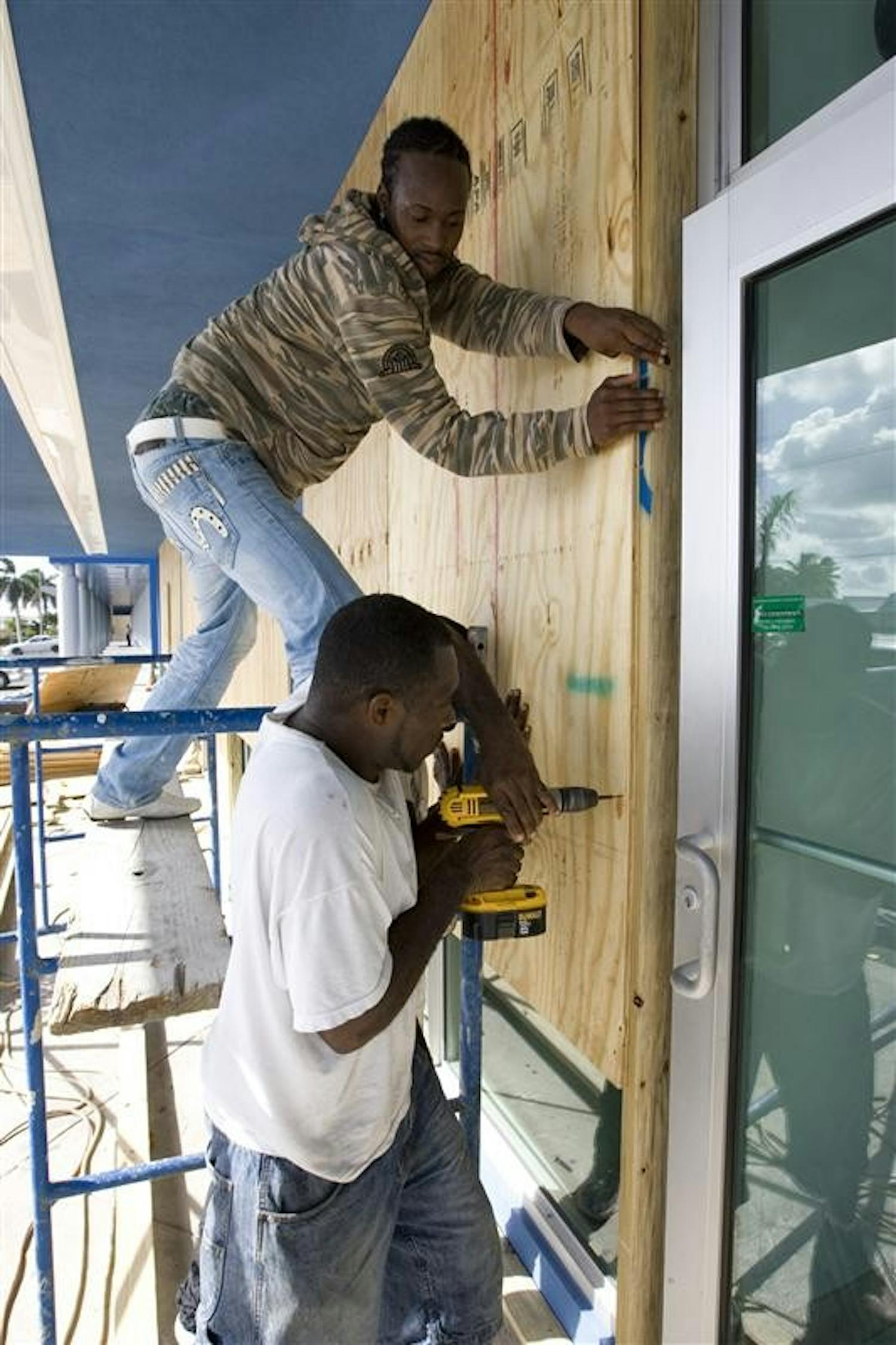 Workers board up windows in preparation for the arrival of the Gustav storm system, in George Town, Grand Cayman Island on Thursday. Gustav surged toward renewed hurricane force on Thursday as it drove toward Jamaica, while many miles away, New Orleans watched it with a nervous eye.