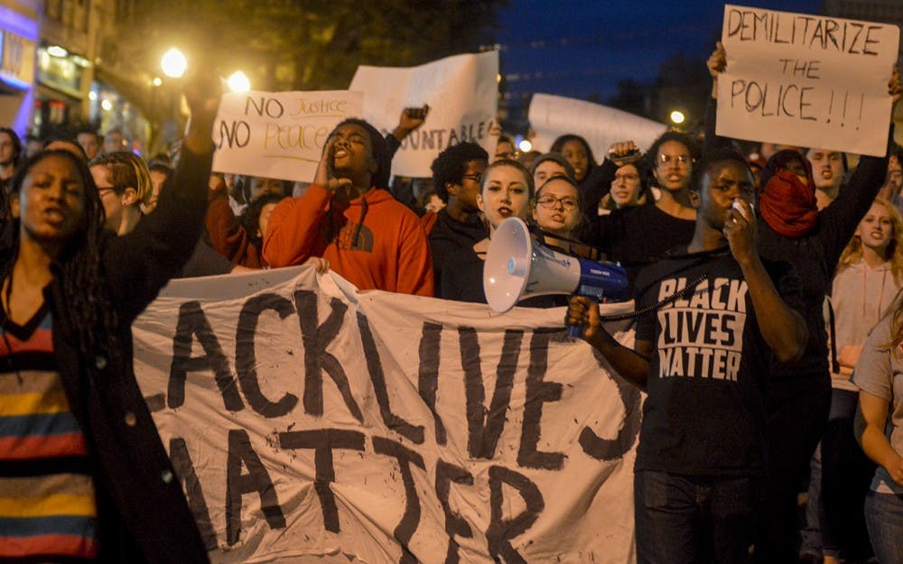 Protesters march to the Bloomington Police Department during the Black Lives Matter protest Monday evening from the sample gates. The event, hosted by Students Against State Violence and the Black Student Union, targeted the Bloomington Police Department because of their failure to bring justice in the 2015 case of Joseph Smedley.