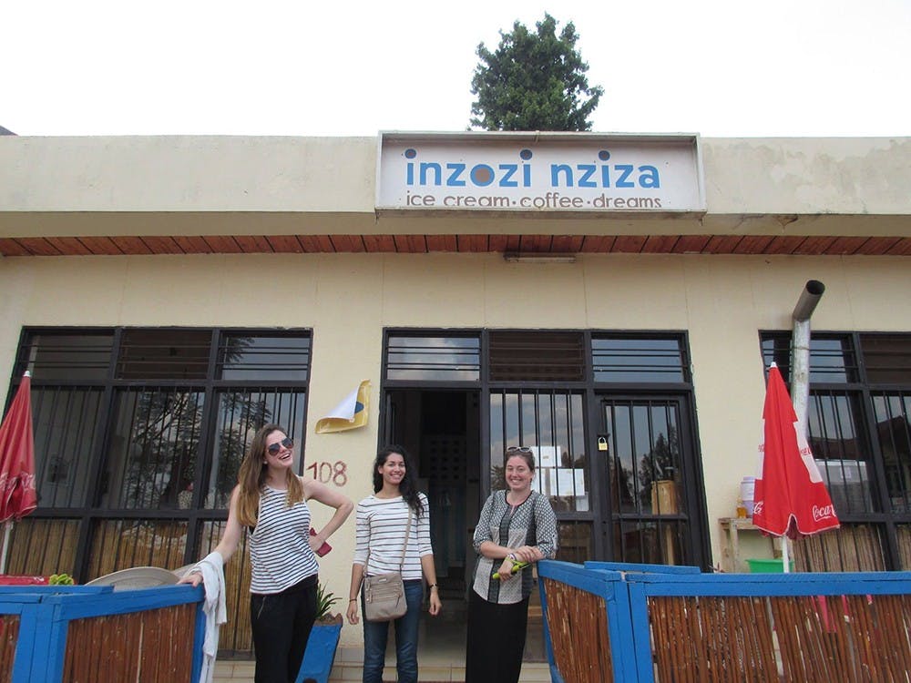 Columnist Caroline Ellert and her fellow study abroad students Lauren Kelley and Kieran Conway stand outside of Inzozi Nziza, a local ice cream shop in Rwanda. Even these small stores tell the story of rebuilding the economy of the country.