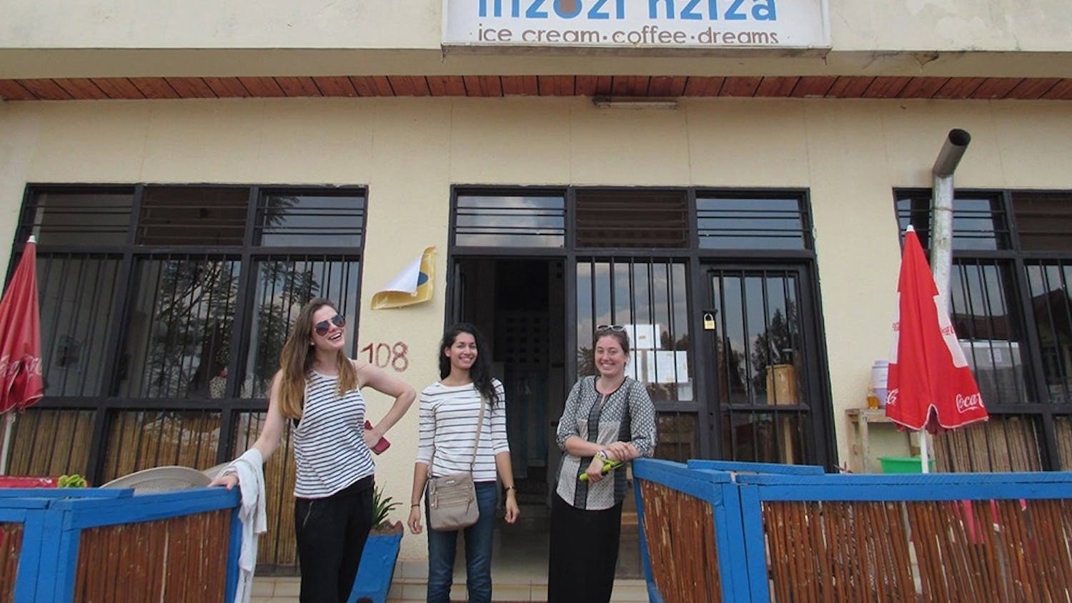 Columnist Caroline Ellert and her fellow study abroad students Lauren Kelley and Kieran Conway stand outside of Inzozi Nziza, a local ice cream shop in Rwanda. Even these small stores tell the story of rebuilding the economy of the country.