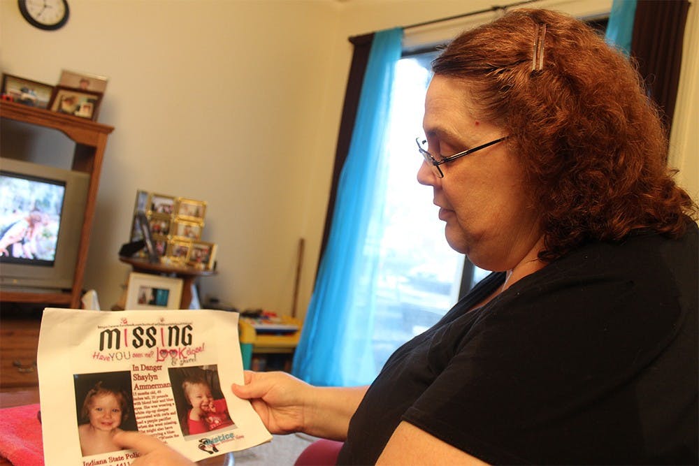 Shaylyn Ammerman's grandmother, Tamara Morgan, displays the fliers she was posting around Spencer on Thursday morning. One-year-old Shaylyn has been missing since early Wednesday morning. 