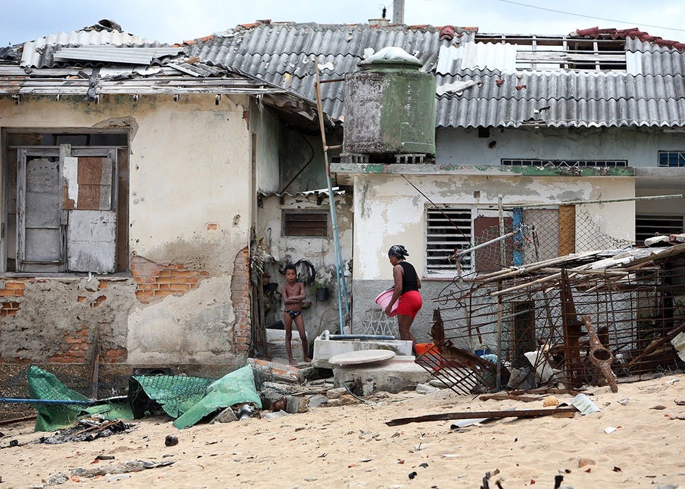 9月28日星期四，海边小镇Jaimanitas的居民在严重受损的房屋外工作。飓风“厄玛”的外围带严重破坏了该镇的许多海滨住宅。
