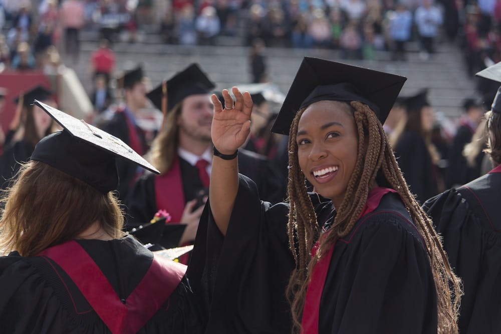<p>A former IU student waves to the audience during the 2018 undergraduate commencement ceremony May 5, 2018, in Memorial Stadium. </p>