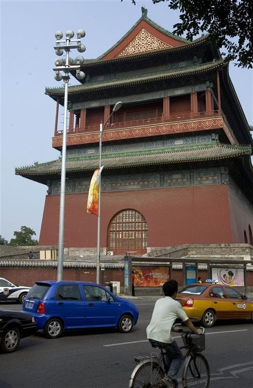 A Chinese man cycles past the Drum Tower in Beijing, China on Saturday. Beijing authorities say a Chinese man attacked two American tourists on the opening day of the Olympic Games, killing one of them before committing suicide.