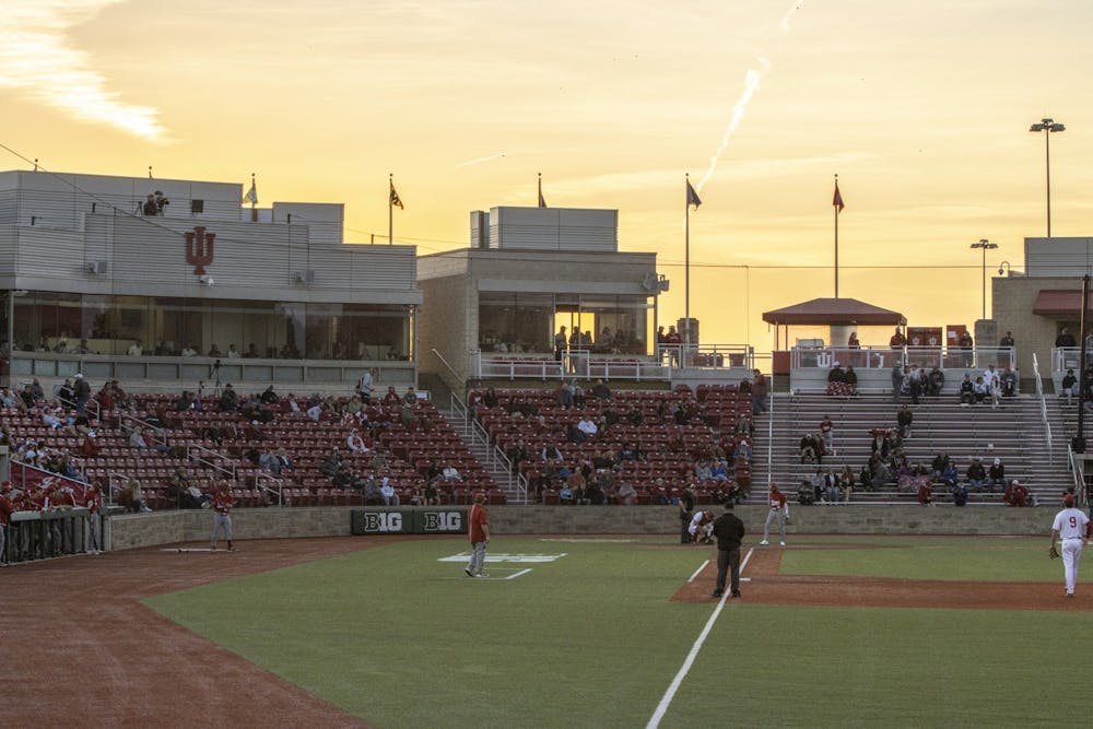 <p>The sun sets behind the stands of Bart Kaufman Field on March 1, 2022. Indiana’s game against Indiana State University, originally scheduled for Tuesday, was postponed due to weather.</p>