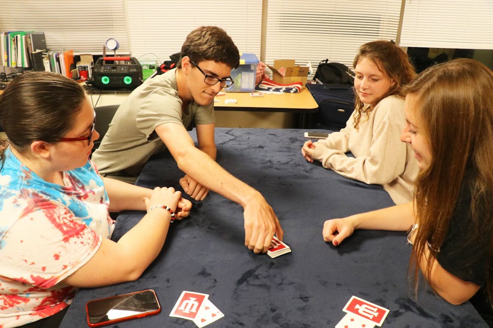 <p>Kenzie Burgess, Reese Myers, Kacie Scales and Jada Collins play a game of euchre on Sept. 17, 2019, in Teter Quad. </p>