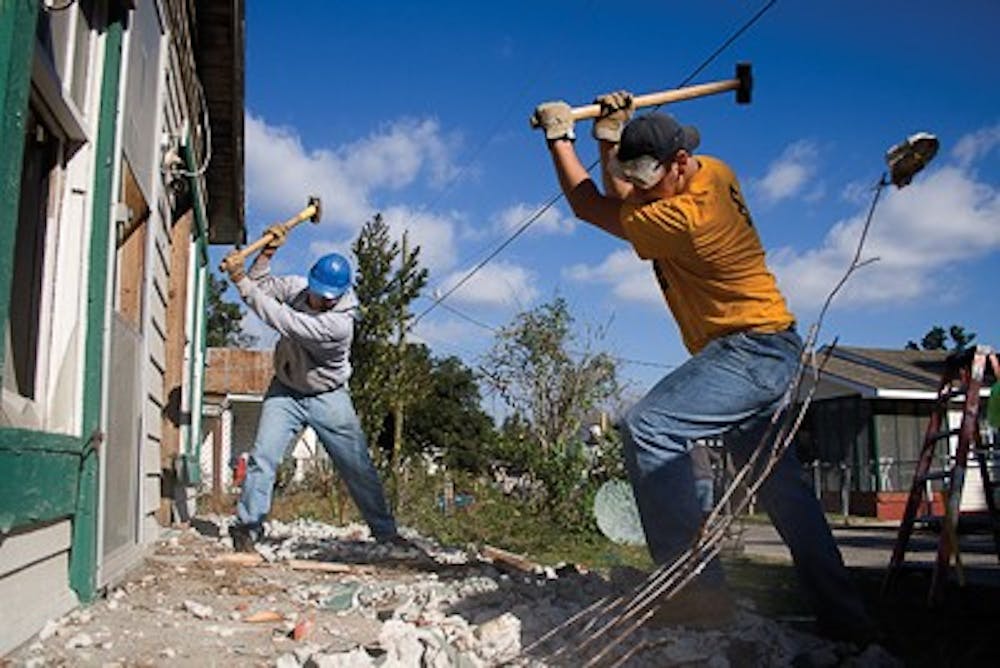 Jay Seawell IDSIU junior Michael Zaremski and IU senior Topher Lenz swing sledgehammers in order to break up the front steps of a house on Elmer Street in Biloxi, Miss.  The city of Biloxi was going to demolish the house, which suffered damage from Hurricane Katrina, Y'ALL executive board member and trip planner Mike Deranek said.  However, the house's owner was financially unable to tear the house down and the city threatened to add the cost of demolition to the owner's taxes, Deranek said.  Without the help of Y'ALL, the city would have repossessed the property, he said.