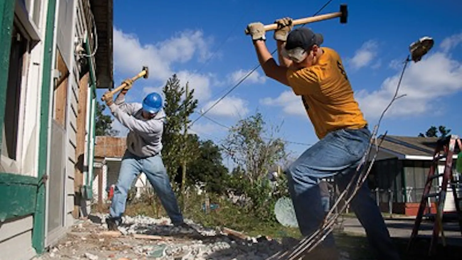 Jay Seawell IDS
IU junior Michael Zaremski and IU senior Topher Lenz swing sledgehammers in order to break up the front steps of a house on Elmer Street in Biloxi, Miss. The city of Biloxi was going to demolish the house, which suffered damage from Hurricane Katrina, Y'ALL executive board member and trip planner Mike Deranek said. However, the house's owner was financially unable to tear the house down and the city threatened to add the cost of demolition to the owner's taxes, Deranek said. Without the help of Y'ALL, the city would have repossessed the property, he said.