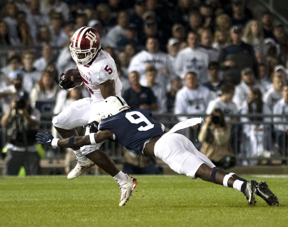 <p>Graduate running back Stephen Carr attempts to elude a tackler against Penn State on Oct. 2, 2021, at Beaver Stadium. Indiana lost to Penn State 24-0.</p>