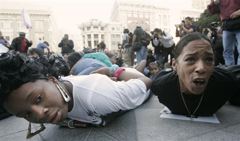 Protesters lie on the ground in a mock arrest pose during a protest against the shooting death of Oscar Grant  in Wednesday in Oakland, Calif.  A former transit police officer has been charged with murder for the fatal shooting of an unarmed and allegedly restrained black man in a racially charged case that has outraged residents and community leaders and set off violent protests. 