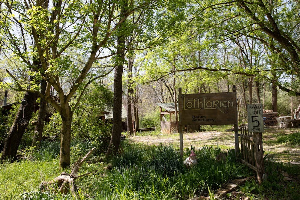 <p>A hand-painted sign reads “Lothlorien Nature Sanctuary” on May 1, 2022, at the entrance of the 121 acre patch of forested land near Judah, Indiana. The community is home to a handful of full-time residents and more than 400 members.</p>